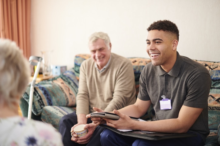 Charity copywriter representer by a charity volunteer with an elderly man.