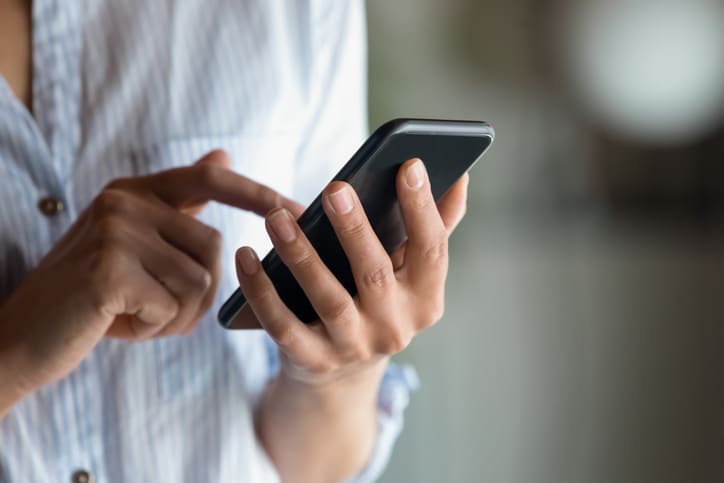 Email copywriter represented by a woman holding a phone.